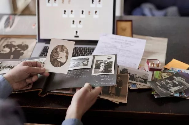 Person conducting family history research by looking at photographs