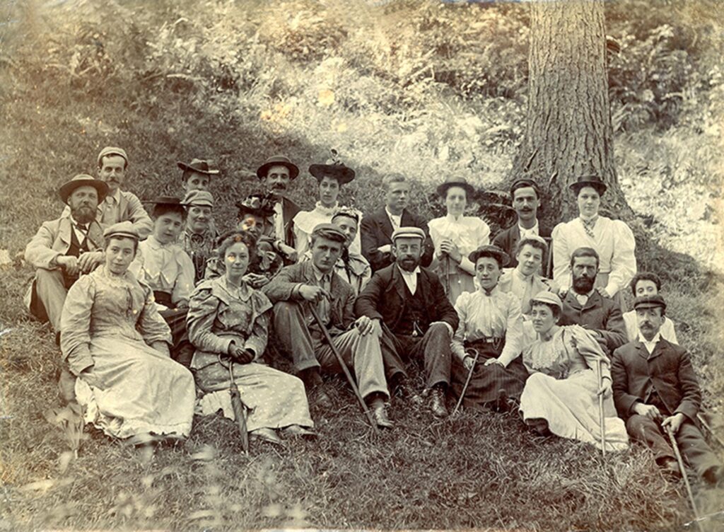 Old photo of a large family sat on a hill