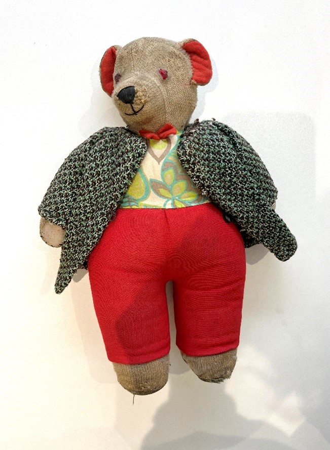 Teddy bear with a green jacket and red trousers