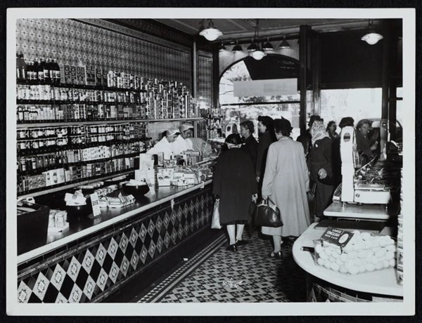 Black and white image of people lining up at a shop counter from the Sainsbury's archive.